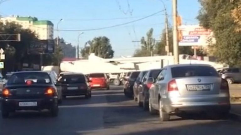 Kolona të gjata në qytetin rus, aeroplani luftarak lëviz ngadalë nëpër udhëkryq