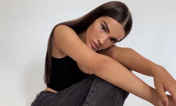 Arbenita pozon e shtrirë me fustanin e shkurtër të zi